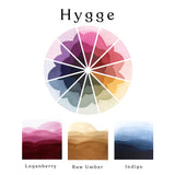 A colour wheel of the Hygge watercolour set and ombre swatches of Loganberry, Raw Umber and Indigo watercolour paints.