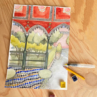 sketch of Moroccan scene with art materials on wooden surface