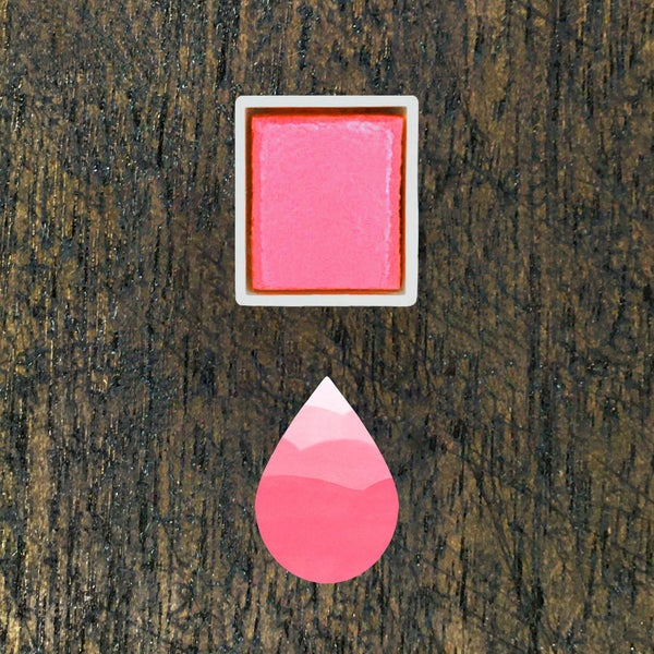Bubblegum watercolour half pan above a droplet shaped ombre swatch in Bubblegum watercolour paint, on a rustic dark wooden background.