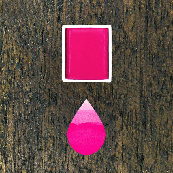 watercolour half pan and droplet shaped ombre swatch in Hot Pink coloured paint on dark wooden background.